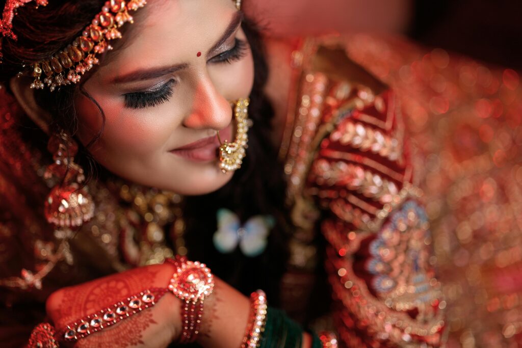 Close-up of a South Asian bride in traditional attire, showcasing elaborate jewelry and henna designs.